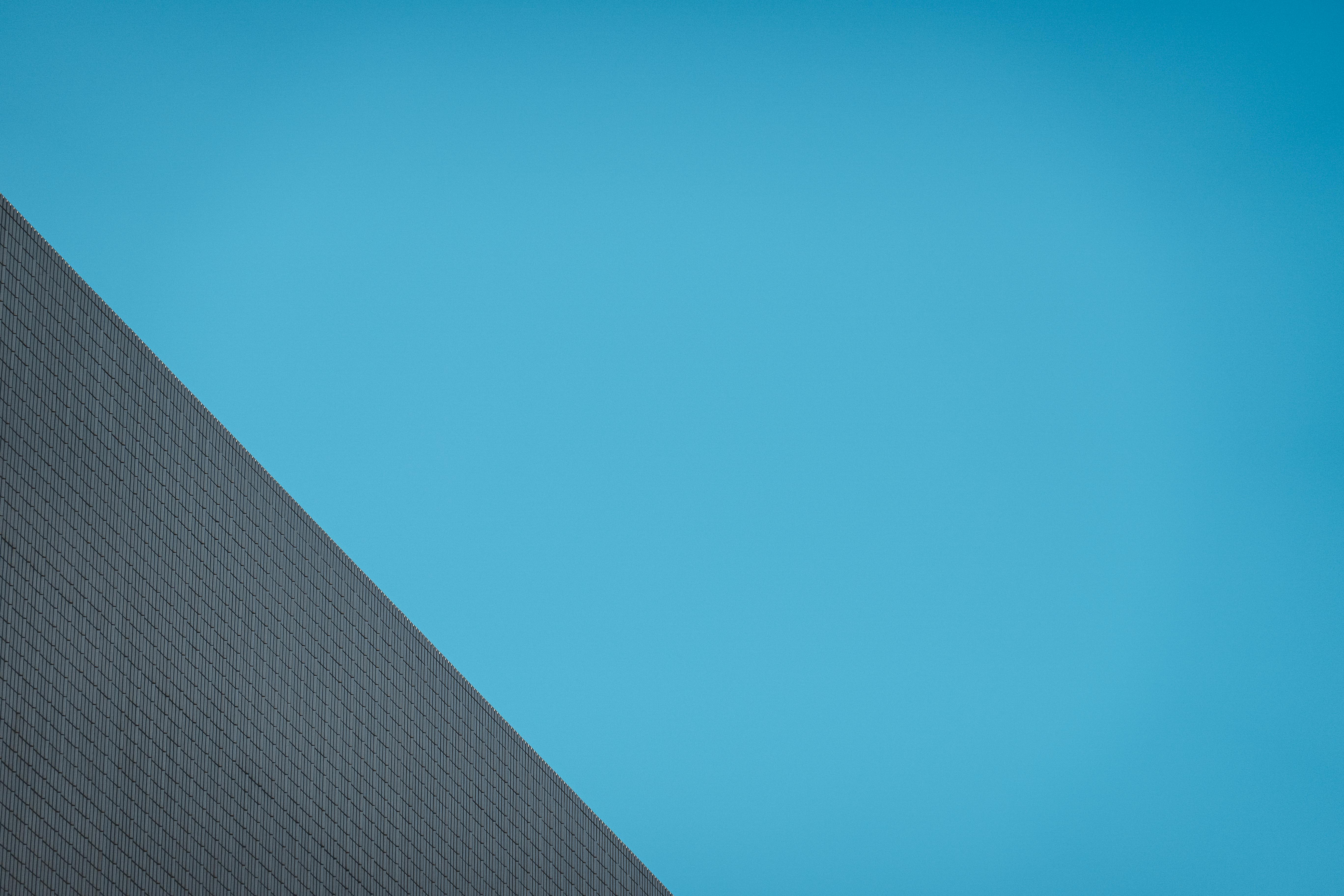 Gratis Geometrisk bygningsfasade fanger moderne arkitektur i Hong Kong mot en klar himmel. Arkivbilde