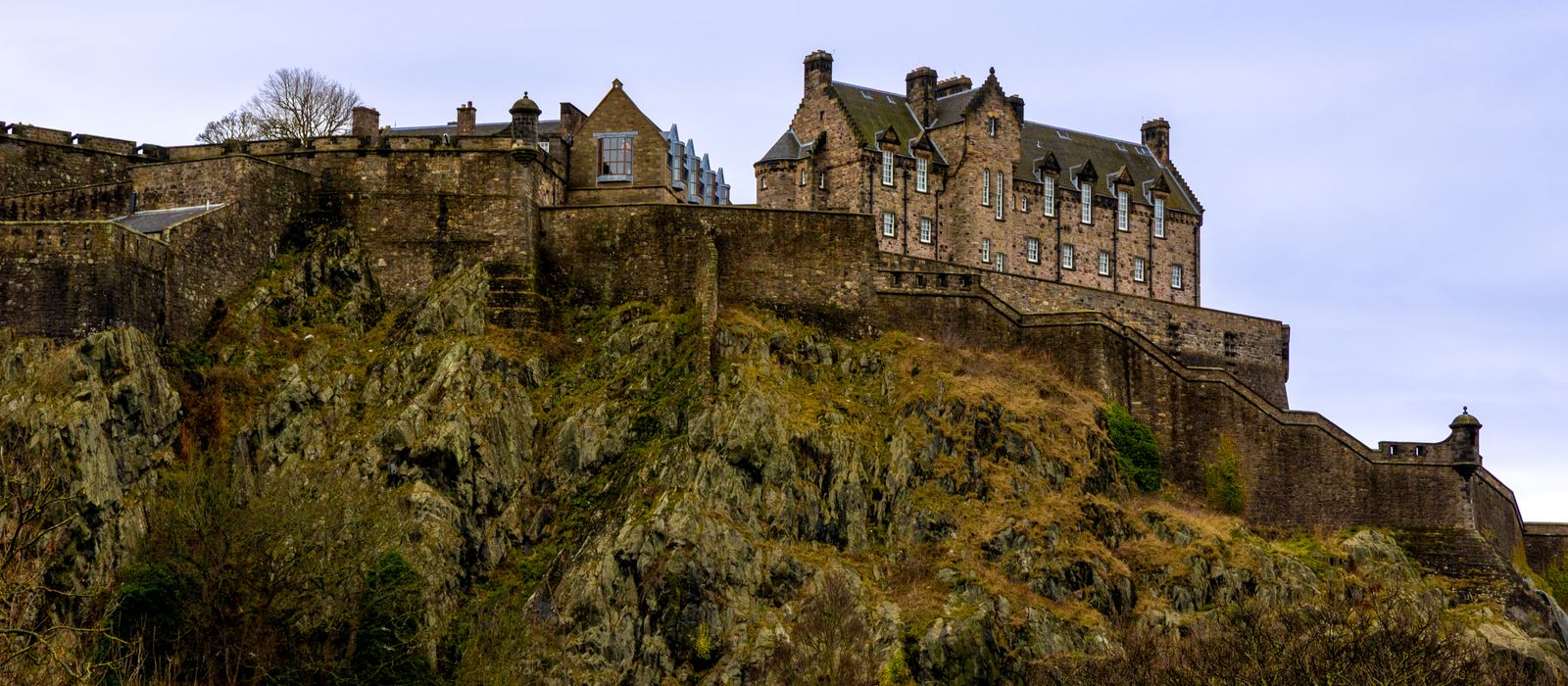 Edinburgh Castle perched on a rocky hill under a cloudy sky, showcasing Scotland's rich heritage.