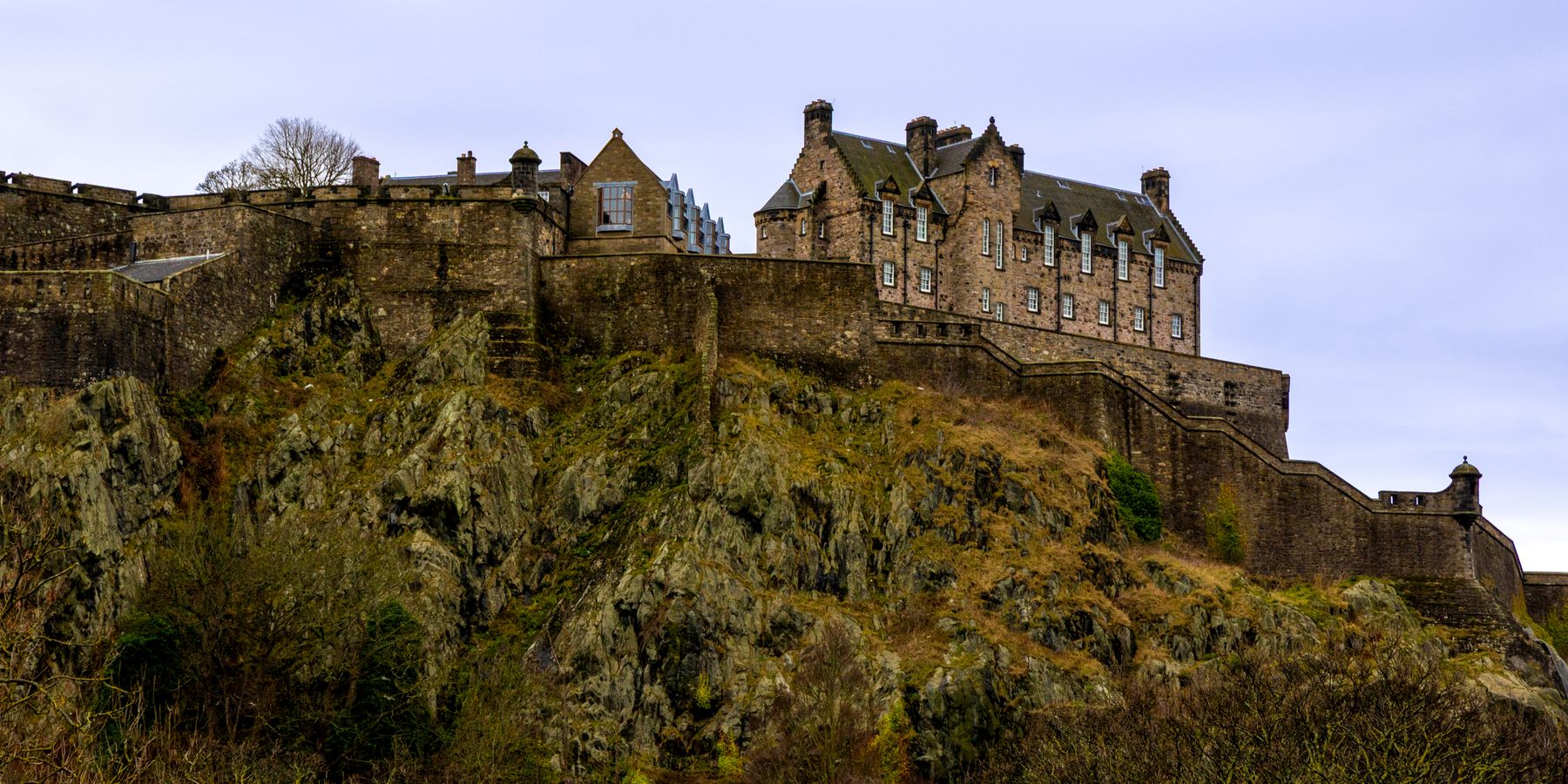 Edinburgh Castle perched on a rocky hill under a cloudy sky, showcasing Scotland's rich heritage.