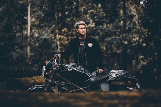 Man with a black vintage motorcycle in a forest, Gold Coast, Australia.