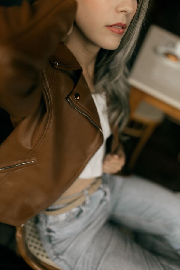 Woman in leather jacket with satin cami and dark jeans