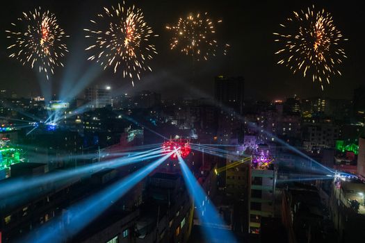 Spectacular cityscape at night showcasing fireworks and vibrant festival lights.
