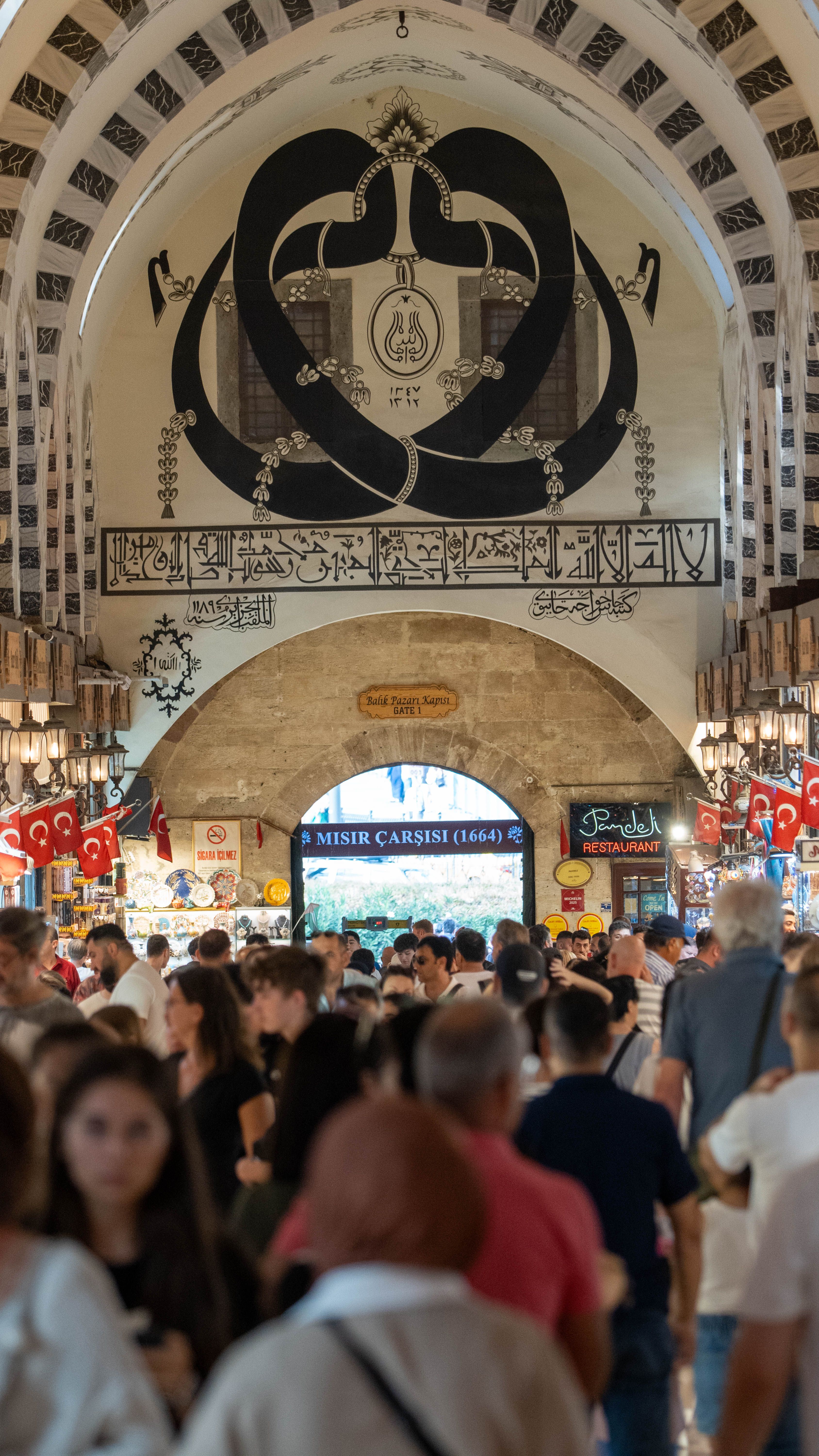 Crowded scene inside the historic Grand Bazaar of Istanbul showcasing architectural details and vibrant crowds.