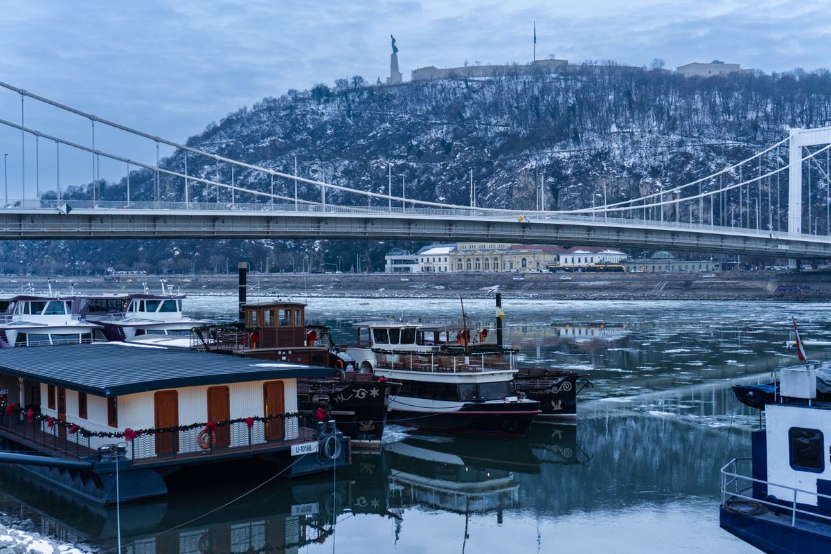 Podul Elisabeta din Budapesta deasupra Dunării cu sloiuri, cu dealul Gellért în fundal
