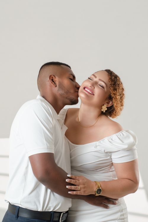 Free Loving couple sharing a tender moment while embracing, dressed in elegant white attire. Stock Photo