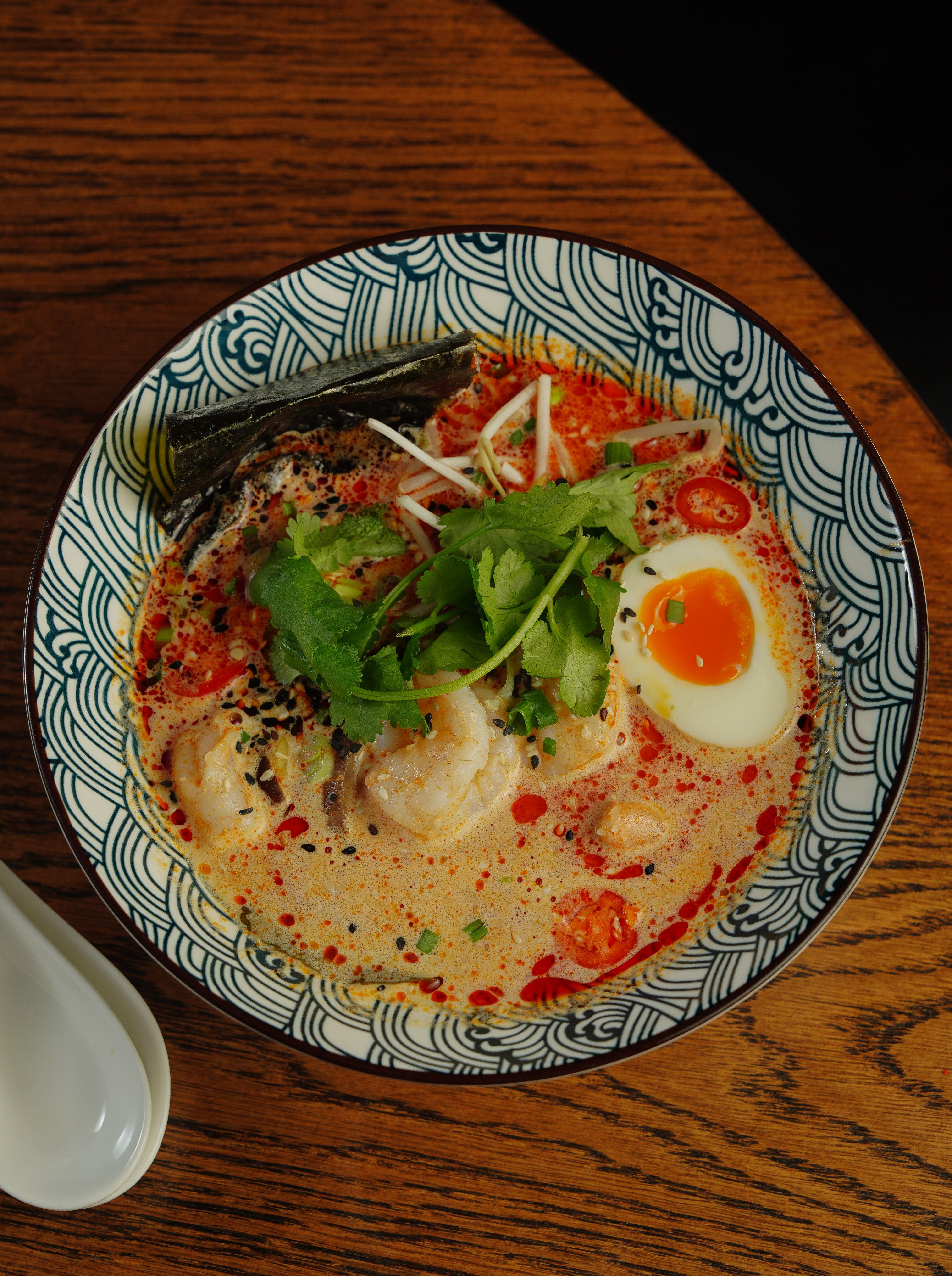 Steaming bowl of Hakata tonkotsu ramen with chashu pork and soft-boiled egg at a traditional Fukuoka restaurant