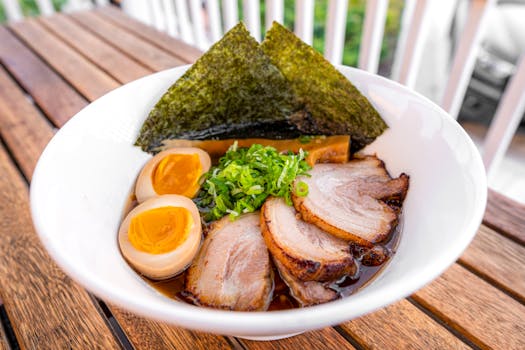 A mouthwatering bowl of ramen with pork, egg, seaweed, and fresh green onions.