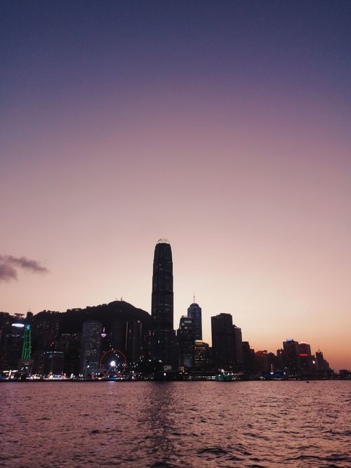 Free Stunning view of the Hong Kong skyline at sunset, featuring iconic skyscrapers and Victoria Harbour. Stock Photo