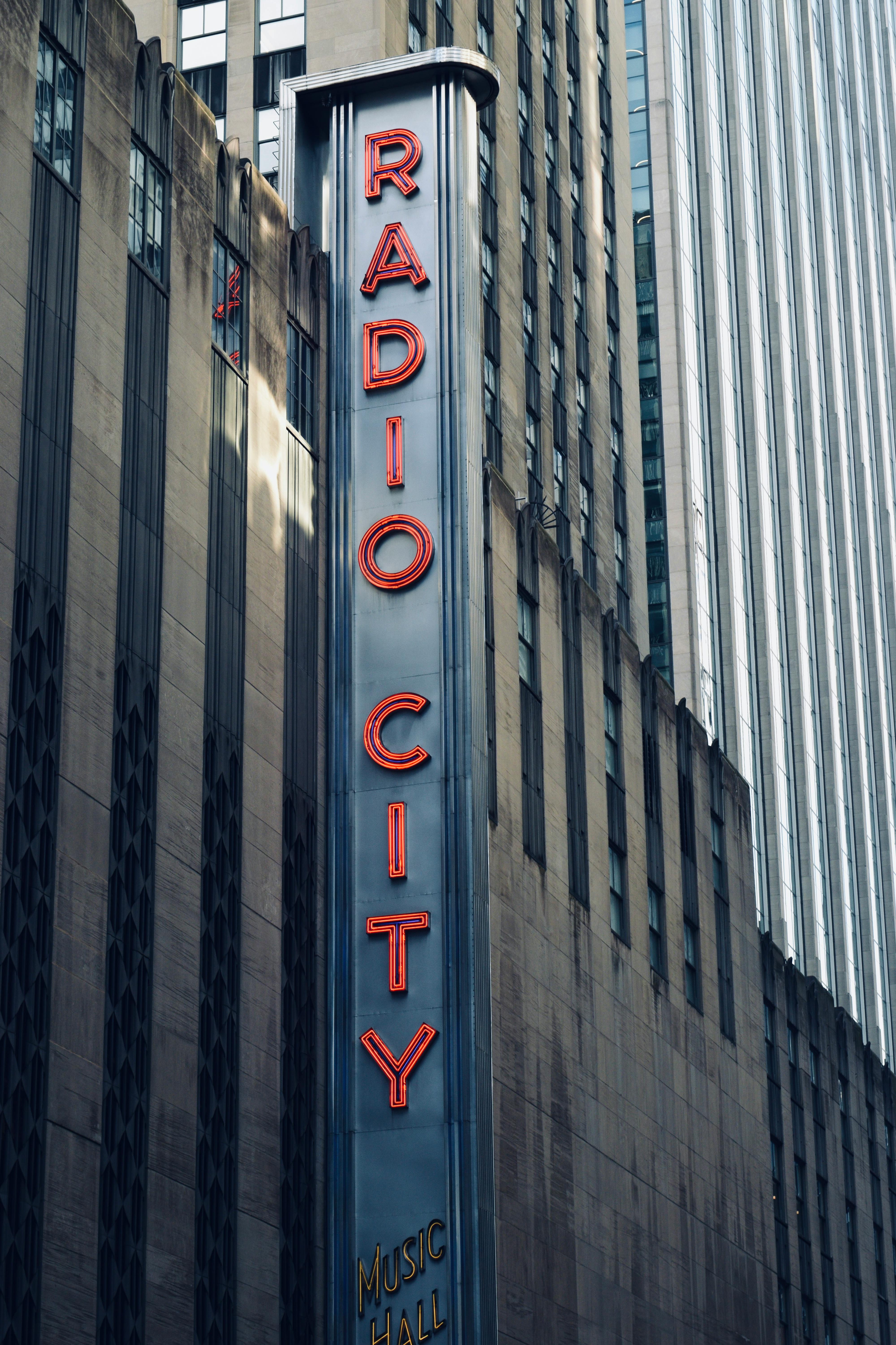 Gratis Papan nama neon ikonik Radio City Music Hall di fasad bangunan di Kota New York. Foto Stok