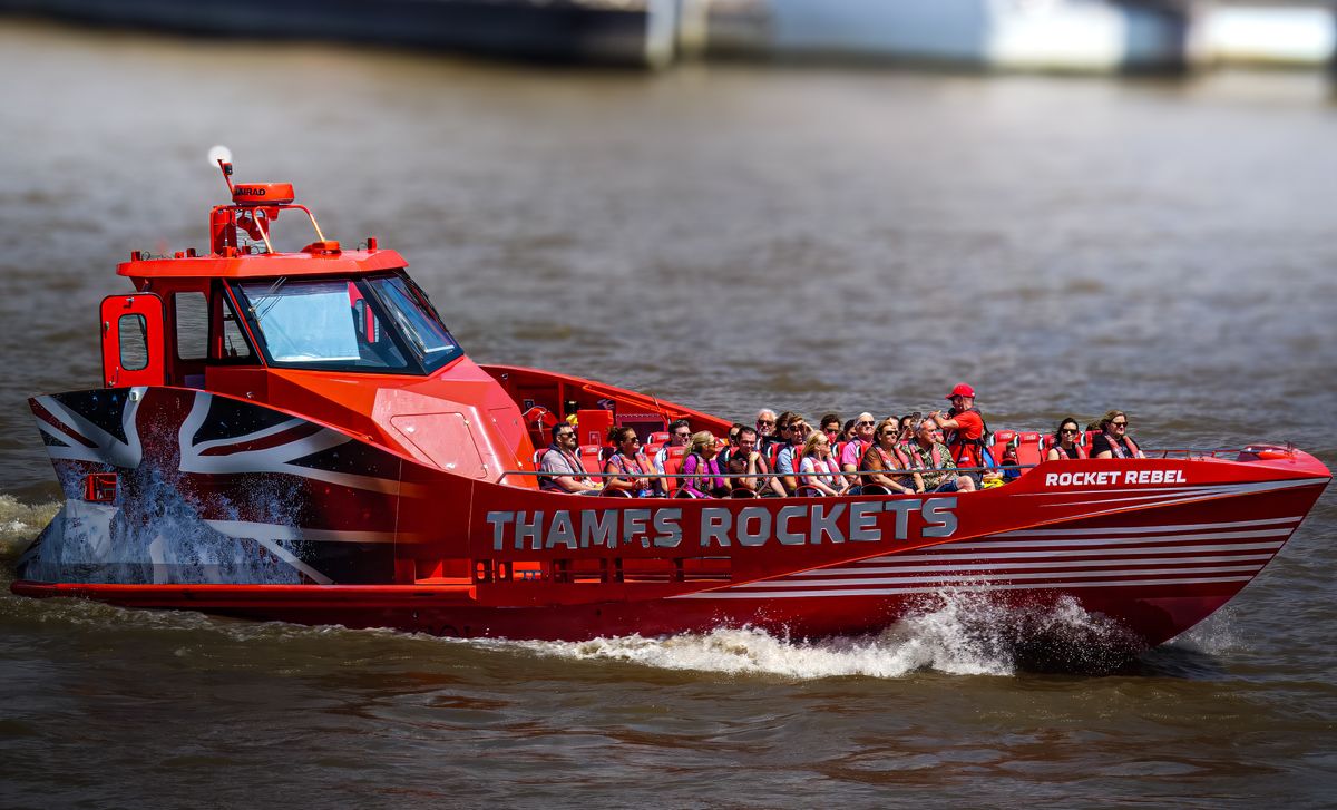 Passengers gripping the rails as a Thames Rockets speedboat throws up spray on the river