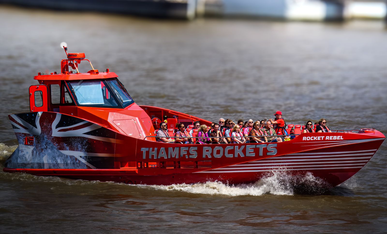 Passengers gripping the rails as a Thames Rockets speedboat throws up spray on the river