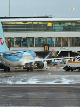An airplane undergoing deicing at an airport terminal in winter conditions.