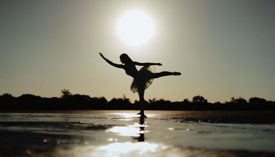 Dancer posed in silhouette against a setting sun. Photo by Maive & Nahuel Fotografia on Pexels