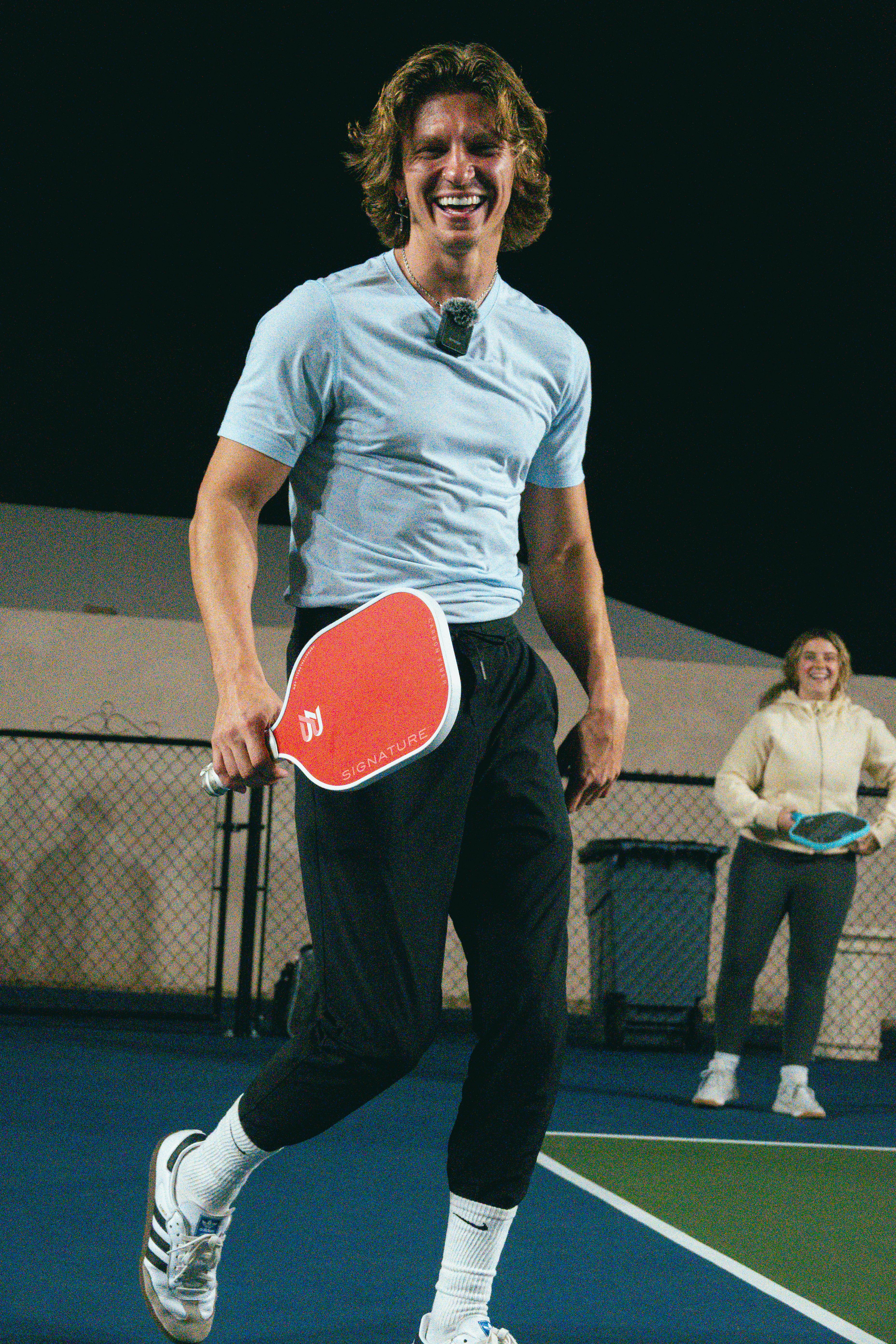 Adults enjoying a lively pickleball game at night in Scottsdale, Arizona.