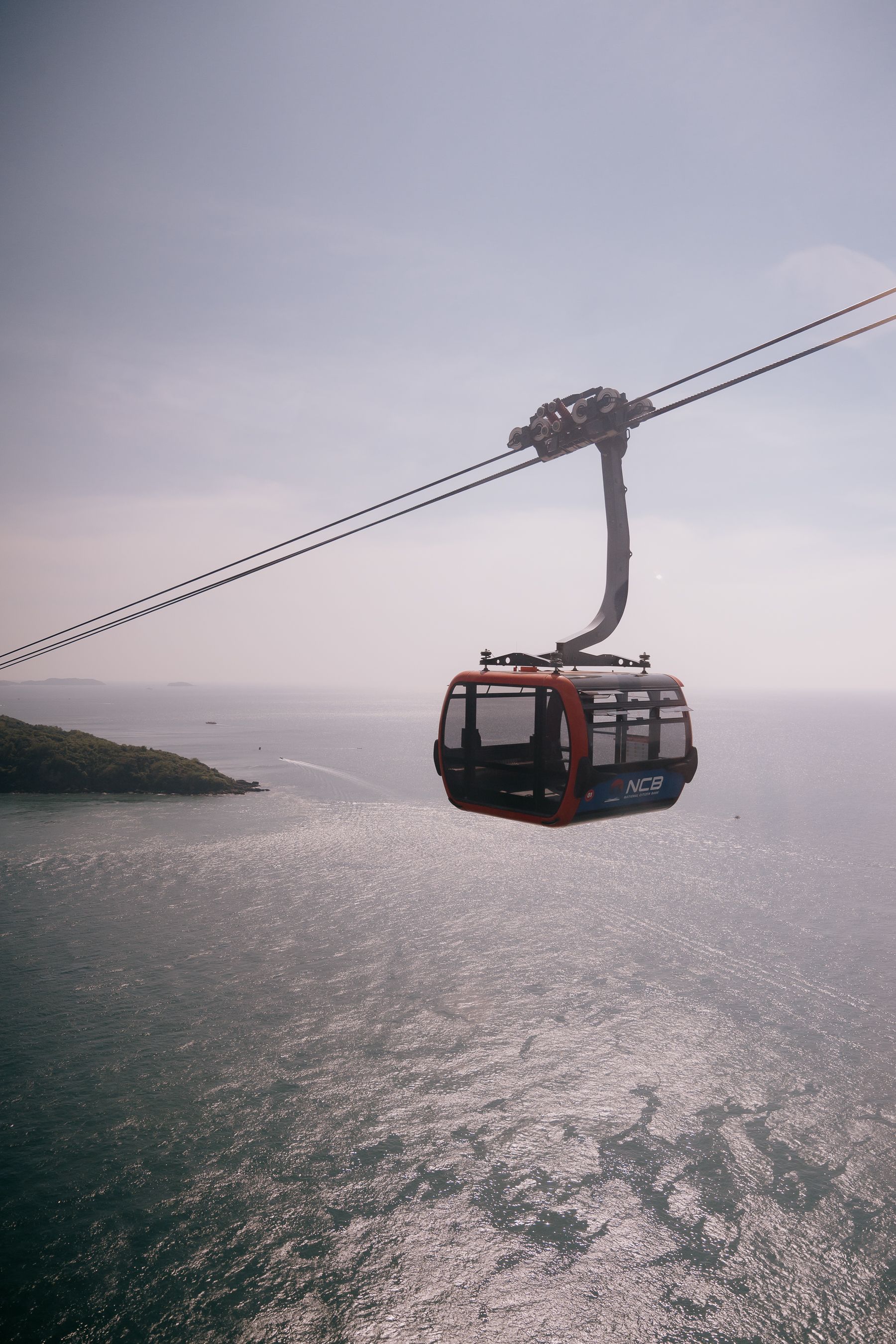 Aerial View of Red Cable Car Over Ocean · Free Stock Photo