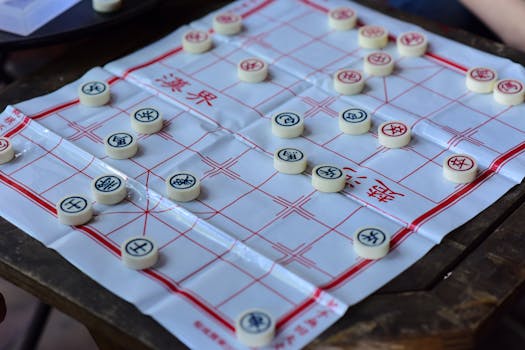 Xiangqi board game setup with pieces on an outdoor wooden table, engaging strategy in play.