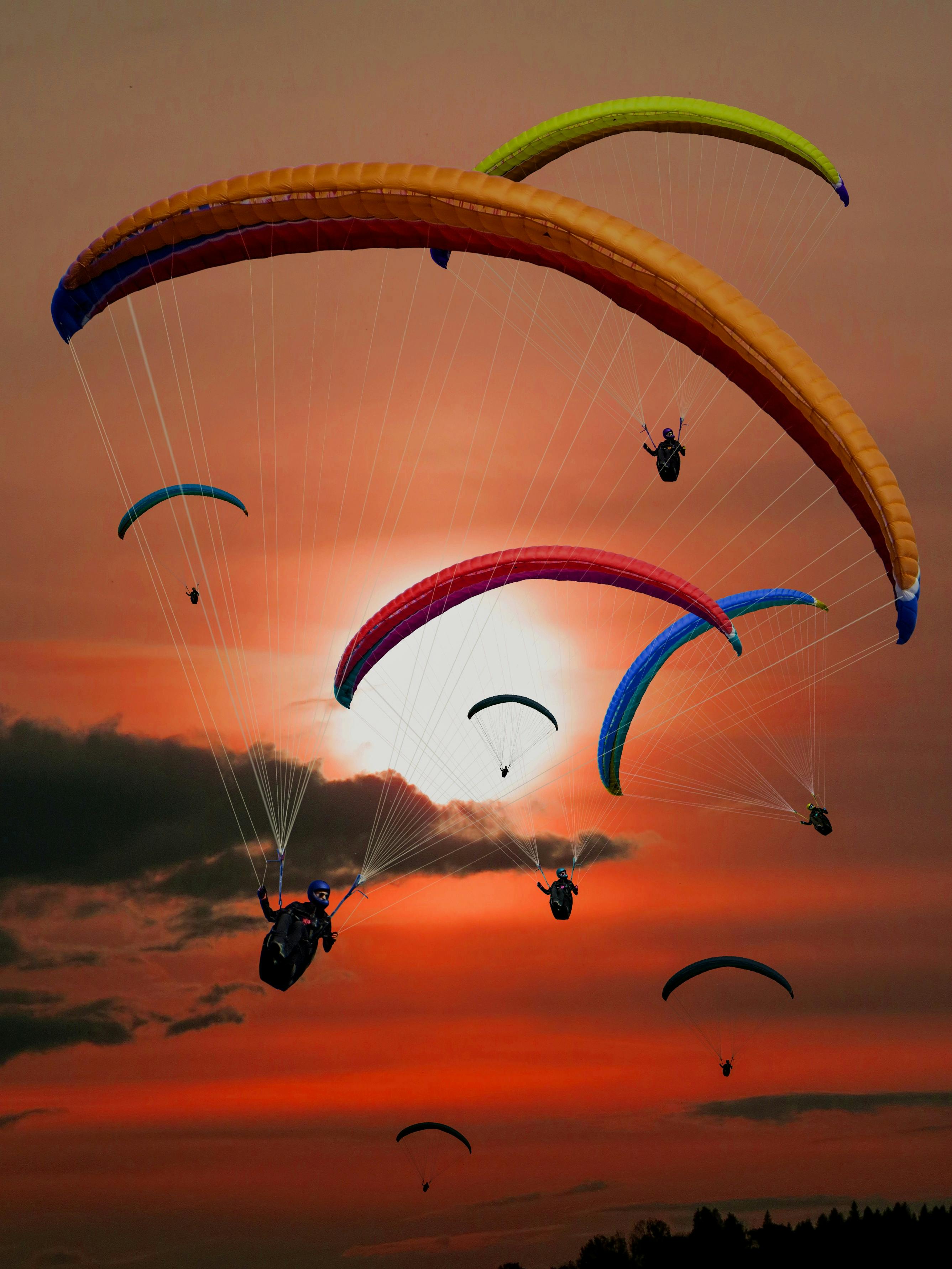 People Riding Parachutes during Sunset