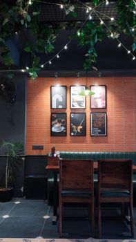 Charming cafe setting with wall art, wooden tables, and lush greenery