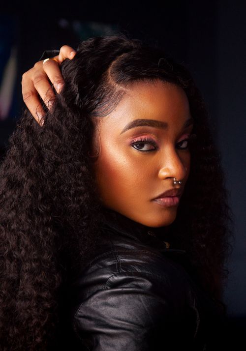 Free Portrait of a fashionable woman with curly hair and septum piercing, exuding confidence. Stock Photo