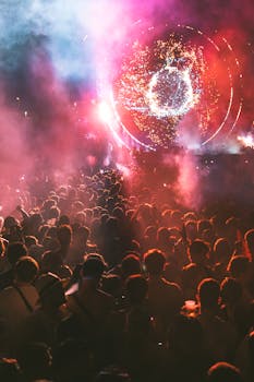 Energetic crowd at a vibrant music festival with colorful lights and fireworks.