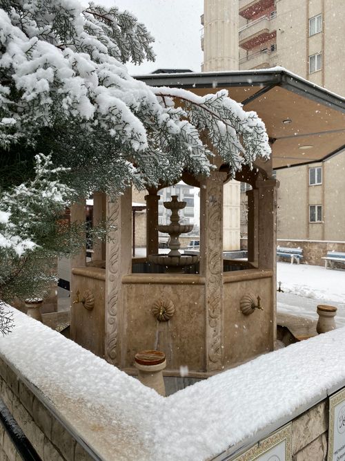 Free Snow-covered fountain in a wintery Kahramanmaraş plaza, showcasing architectural beauty. Stock Photo