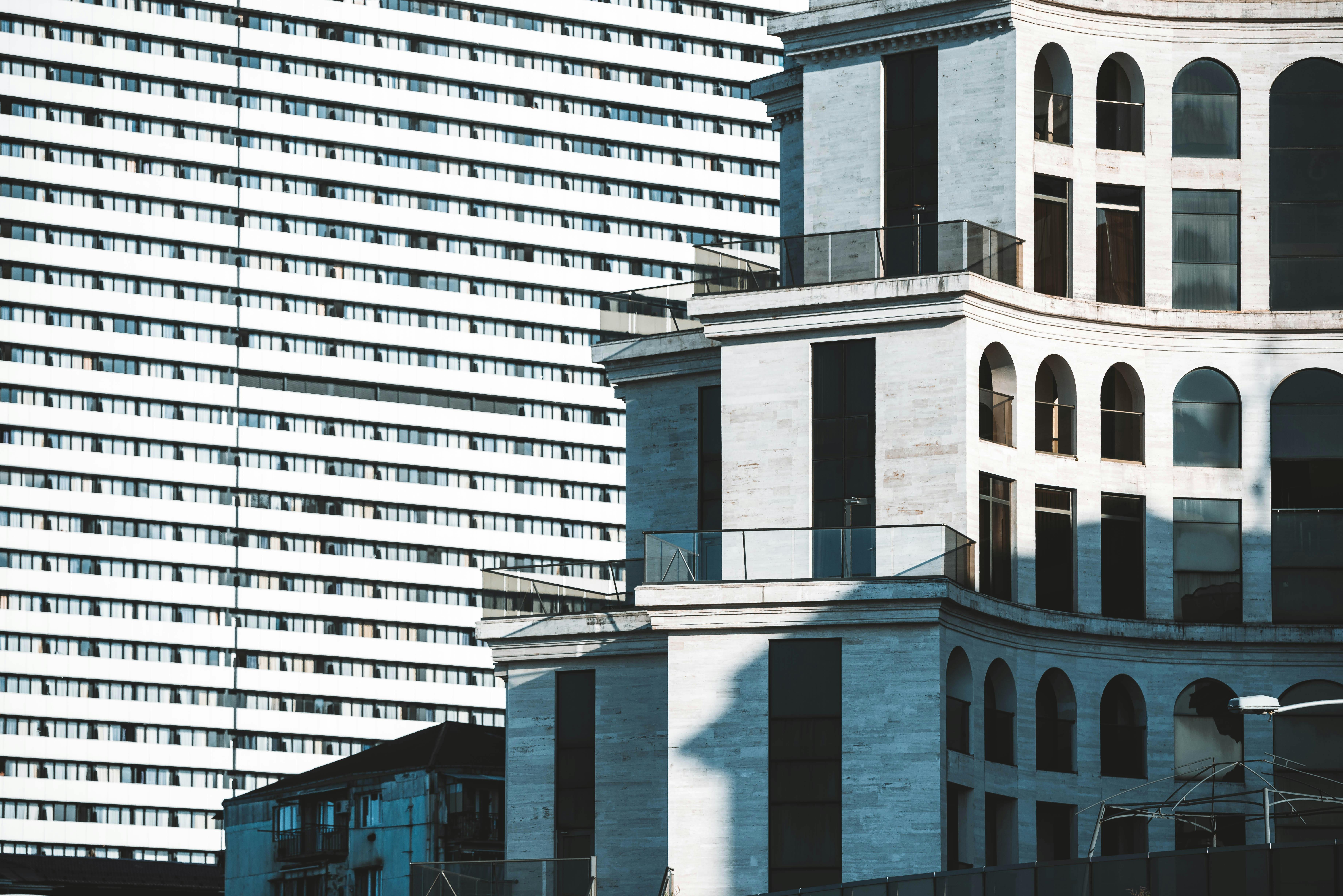 bezplatná Moderní a klasická architektura se prolíná v městské krajině s klenutými okny a texturovanými fasádami. Základová fotografie