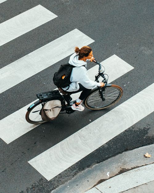 Free Overhead view of a cyclist on a crosswalk in an urban setting, focusing on transportation. Stock Photo