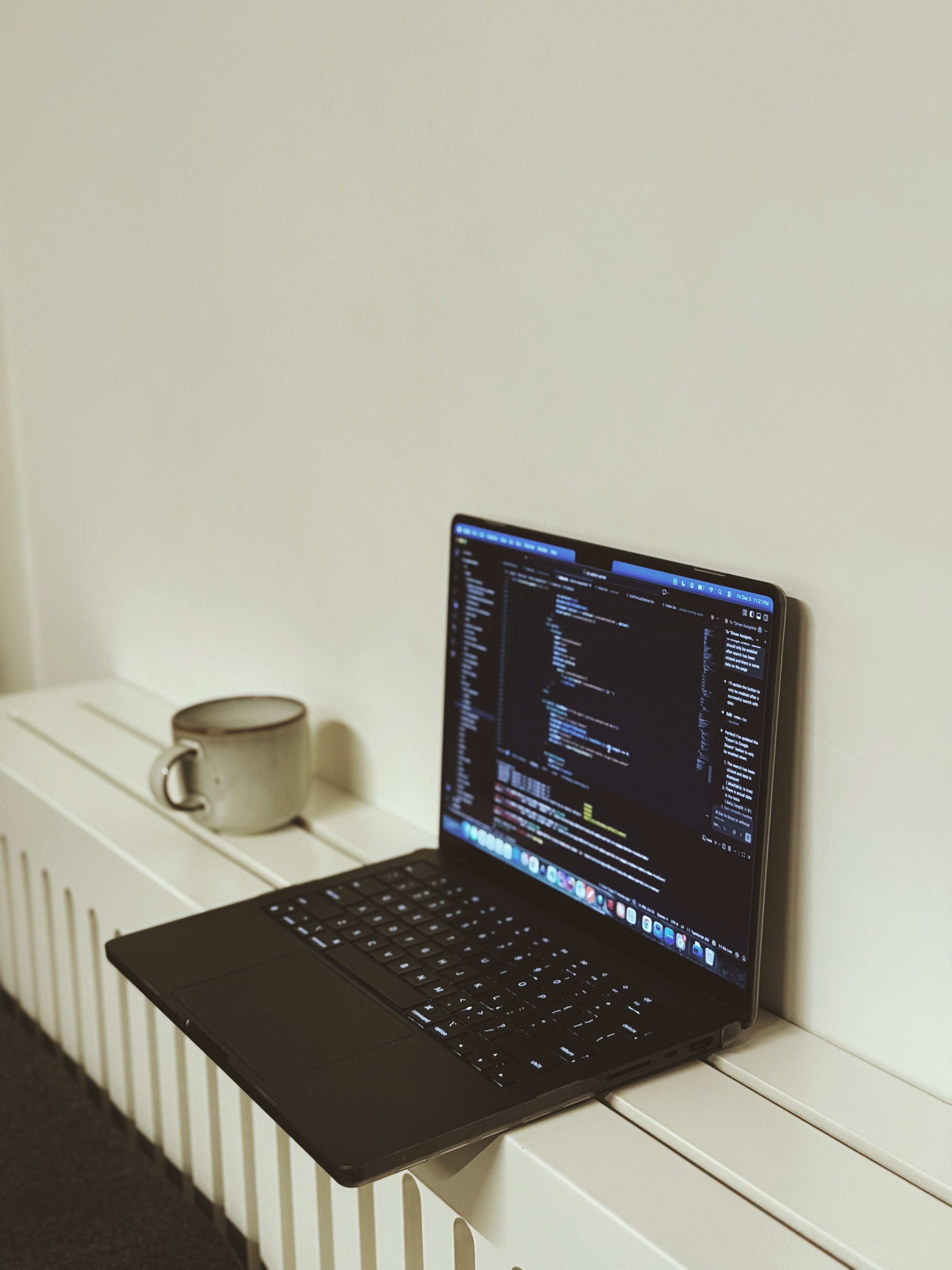 Open laptop displaying code in a minimalist workspace next to a cup, perfect for tech or home office themes. - How to Choose Fast, Lightweight, and AdSense-Friendly WordPress Themes