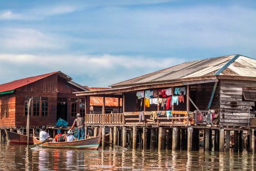 Free Colorful stilt houses and boat in North Sumatra. Scenic view capturing local lifestyle on the water. Stock Photo