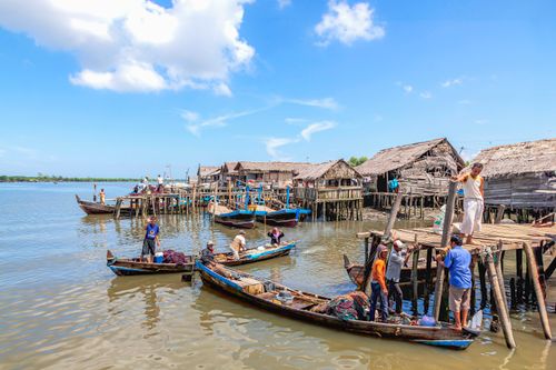 Free Scenic view of a traditional fishing village in North Sumatra, Indonesia with wooden boats and stilt houses. Stock Photo