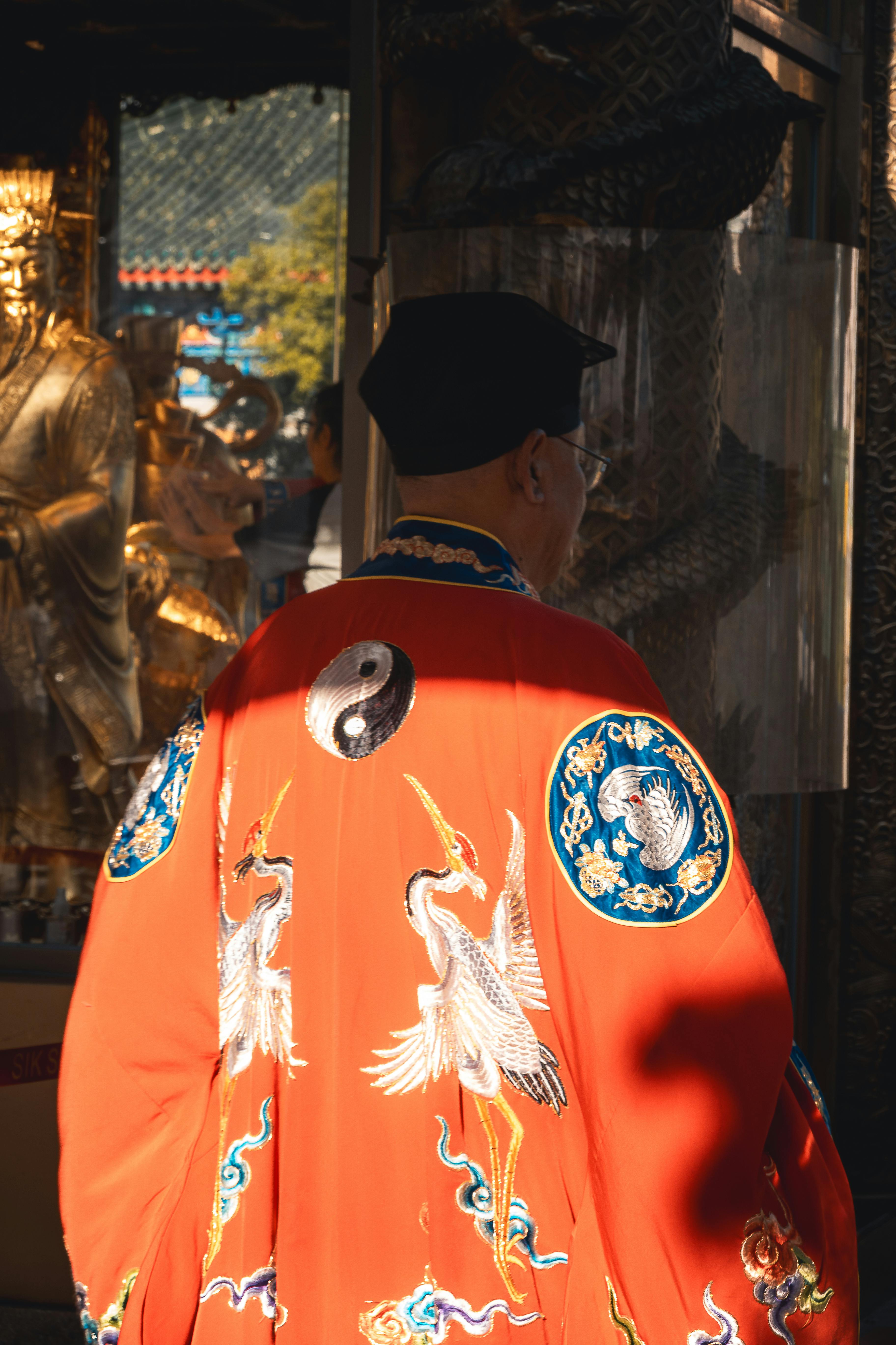 A vibrant traditional Chinese robe with a Yin Yang symbol photographed in Hong Kong temple.