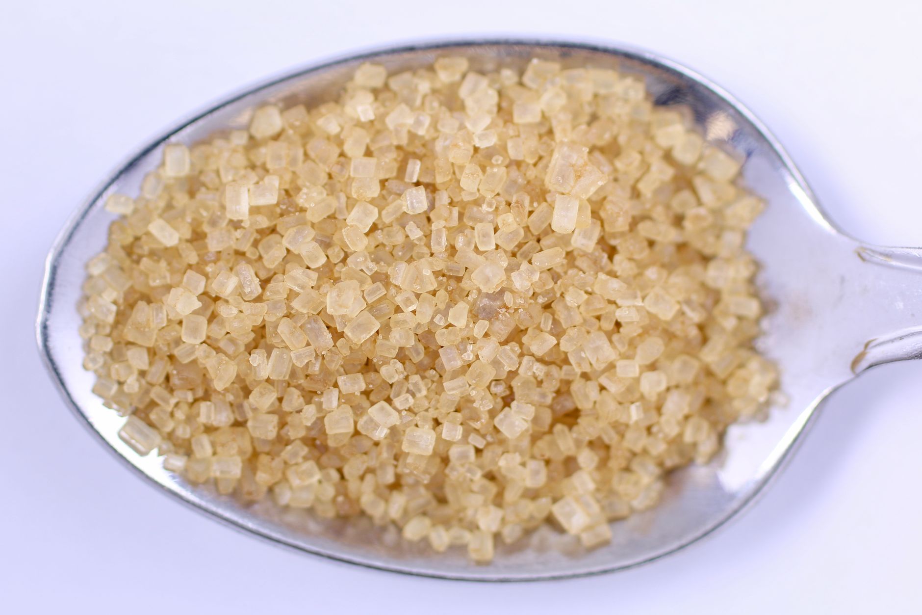 Close-up of raw cane sugar crystals showing light golden colour