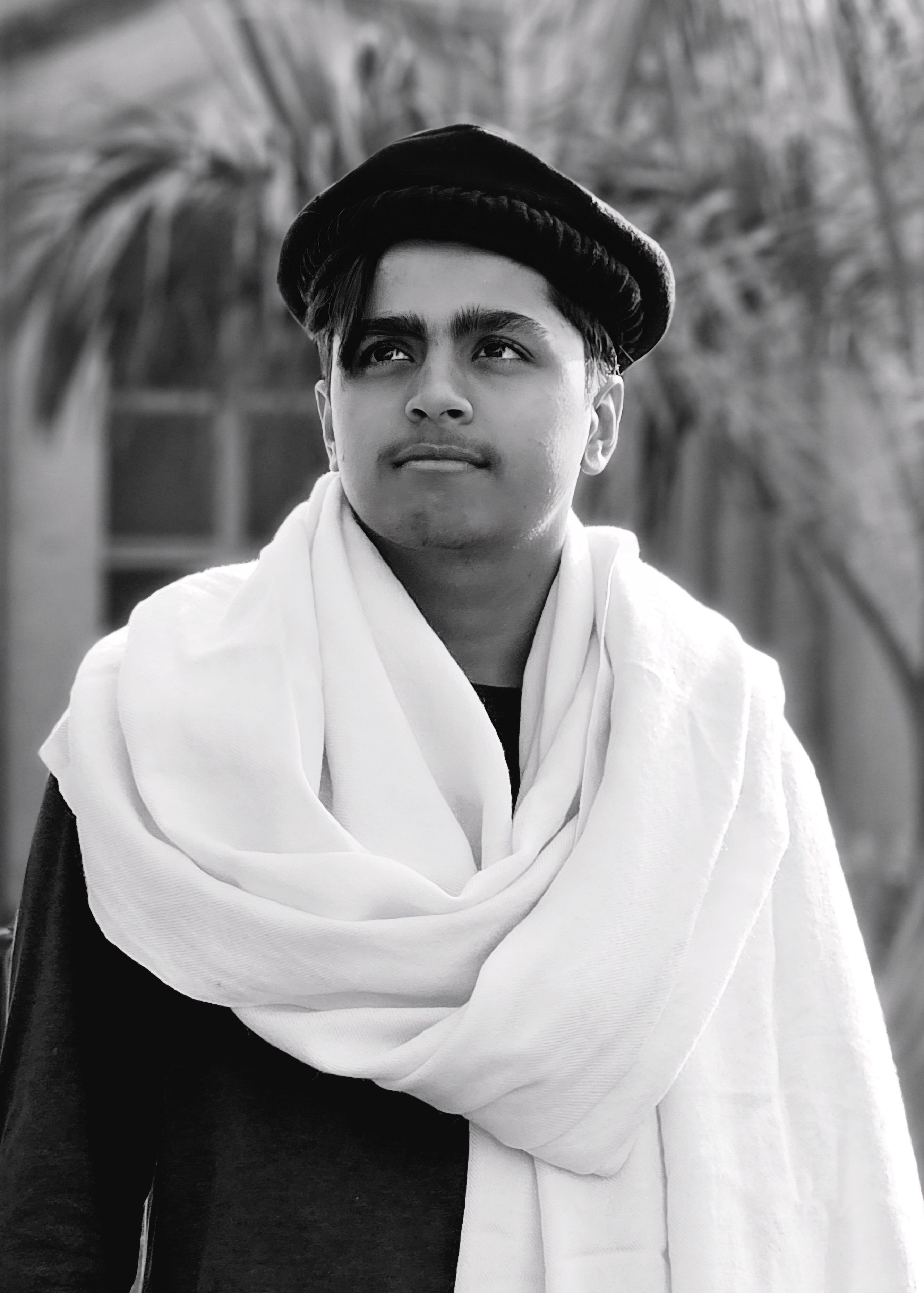 Monochrome portrait of a man in traditional clothing looking off-camera.