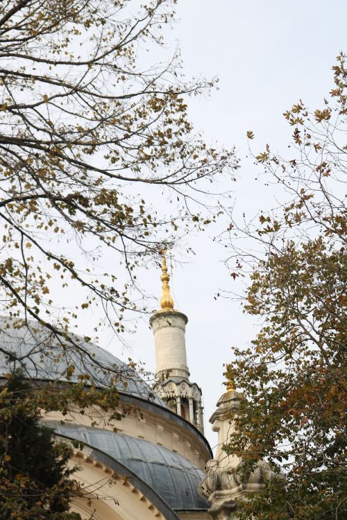 Free A minaret of a mosque surrounded by autumn trees with golden leaves. Stock Photo