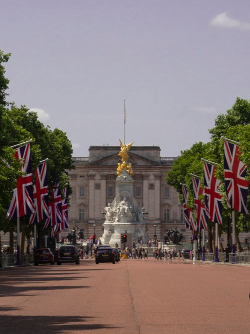 Free View of Buckingham Palace in London with the Union Jack flags lining the street. Stock Photo