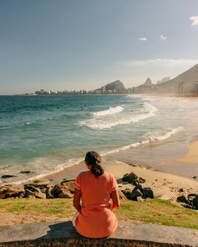 Woman enjoying the ocean view at a Rio beach with Sugarloaf Mountain in the background.
