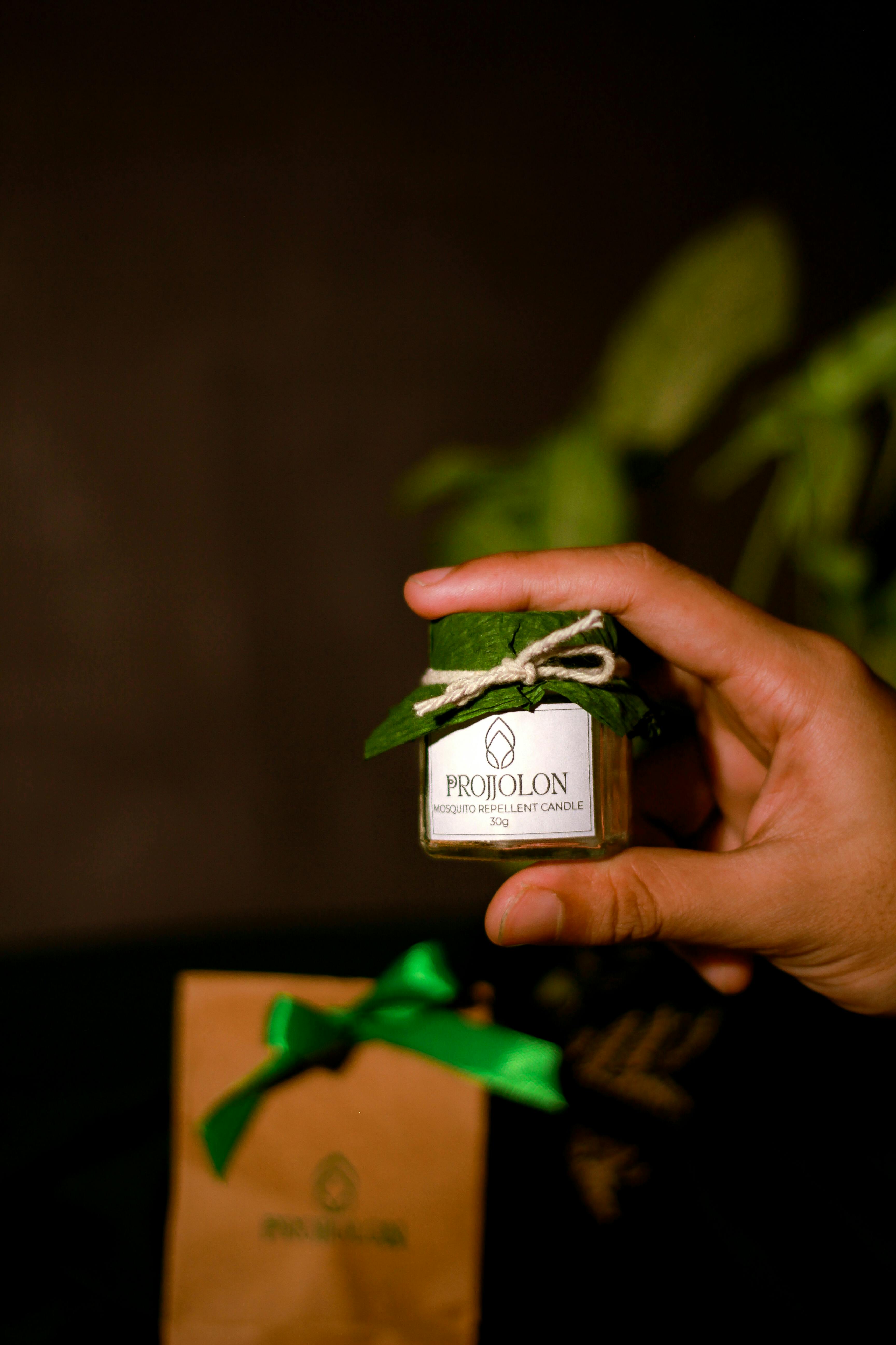 A hand holding a Projjolon mosquito repellent candle, crafted eco-friendly in Dhaka, Bangladesh.
