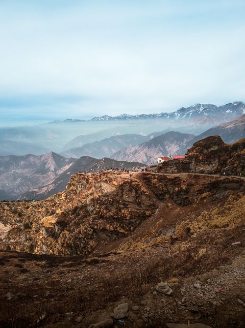 Free Breathtaking view of rugged mountain terrain with distant snow-capped peaks under a clear sky. Stock Photo