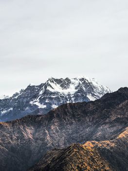 Stunning view of a snow-capped mountain range against a clear sky, showcasing natural beauty.