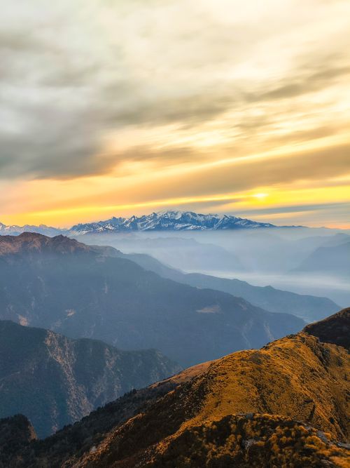 Free Majestic sunrise over snow-capped mountains and misty valleys, creating a serene landscape. Stock Photo