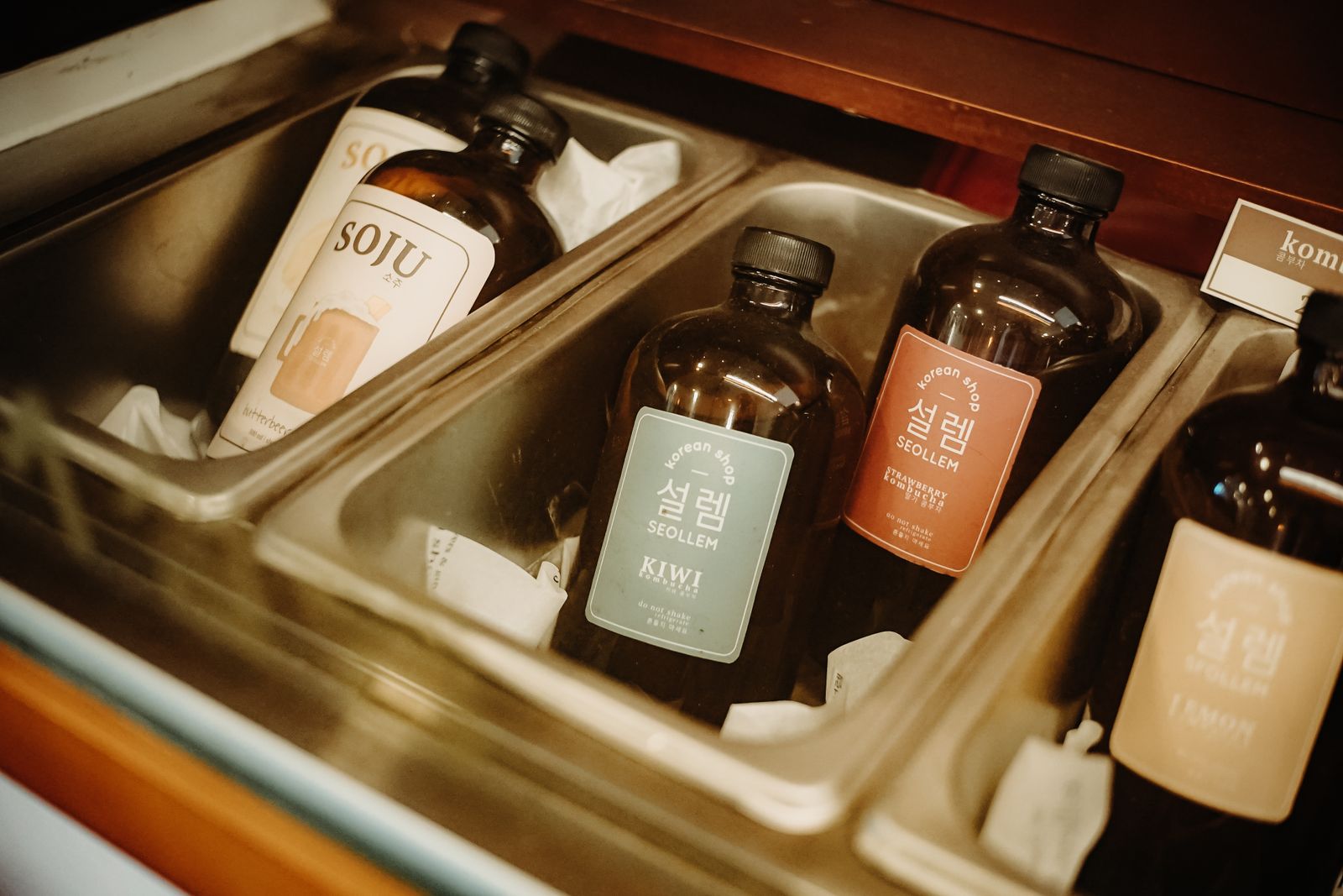 A selection of Korean soju bottles in an ice tray with flavors like kiwi, lemon, and more.