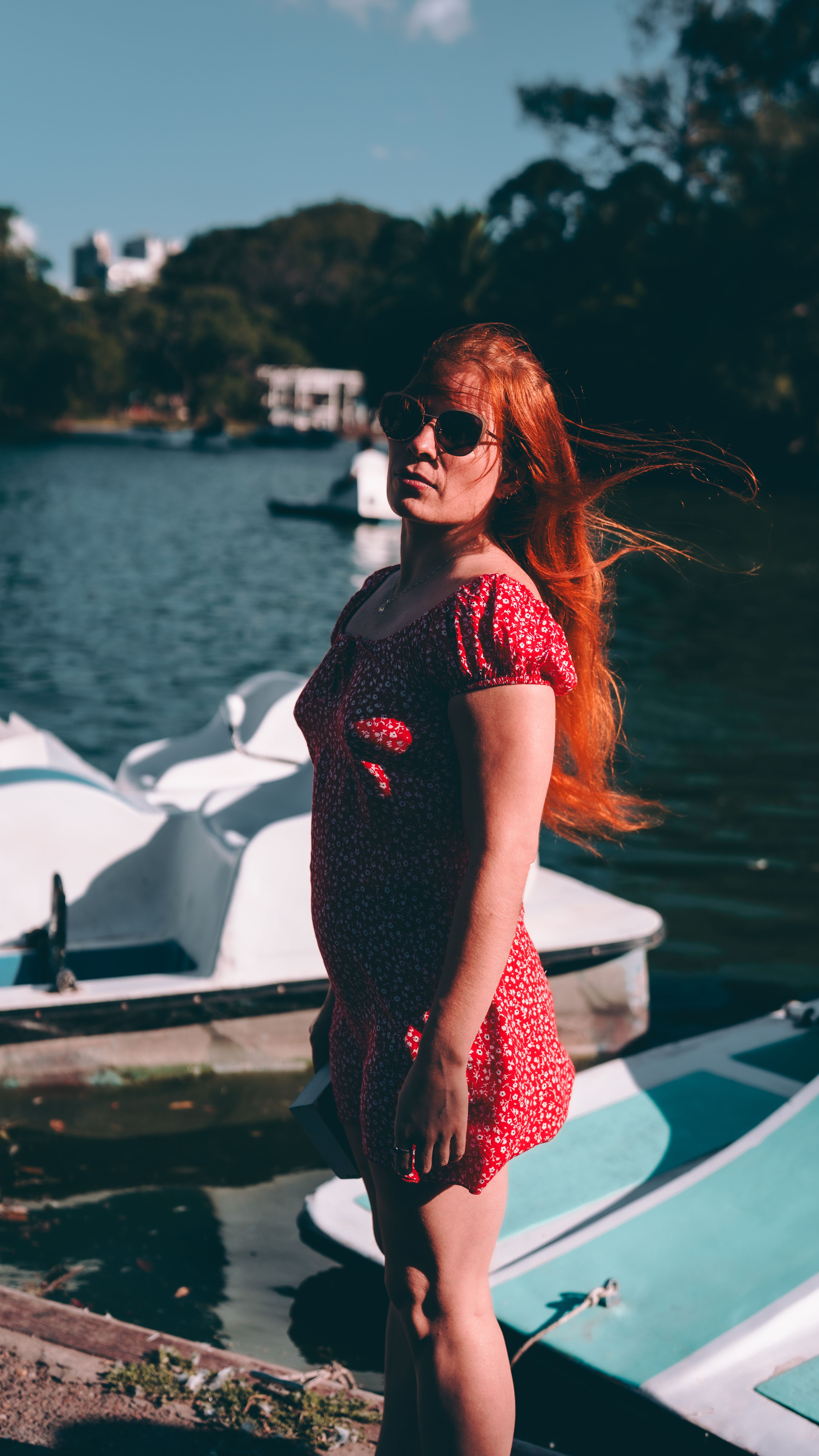 Uma mulher de vestido vermelho aproveitando a vista do lago em Buenos Aires, Argentina.