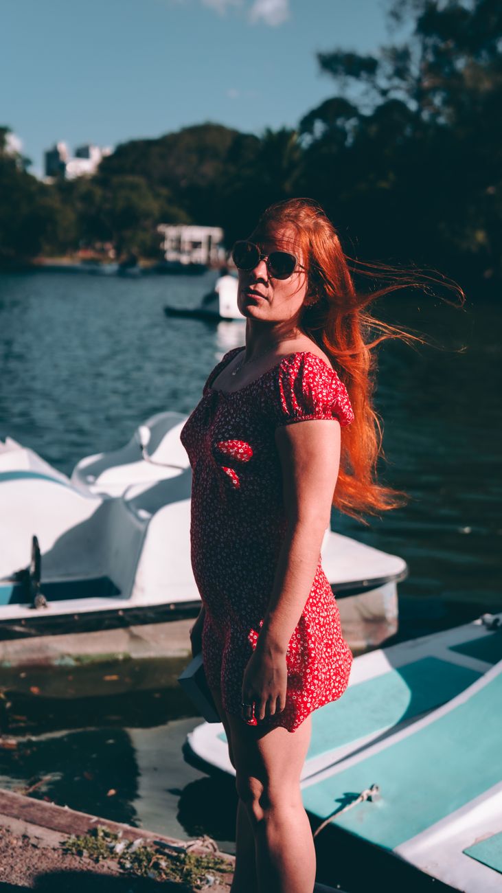 Uma mulher de vestido vermelho aproveitando a vista do lago em Buenos Aires, Argentina.
