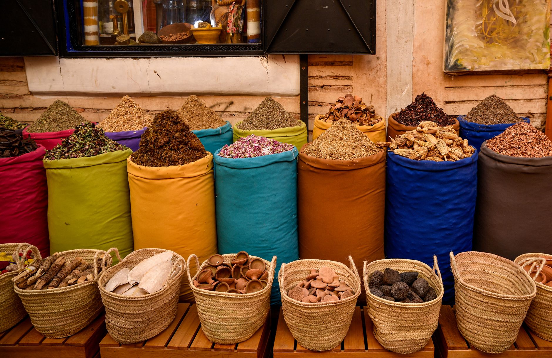 Colorful spice sacks in a Marrakesh souk depicting Moroccan culture.