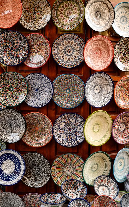 Free Colorful handmade ceramic plates on display in a Marrakesh souk, showcasing traditional Moroccan craftsmanship. Stock Photo