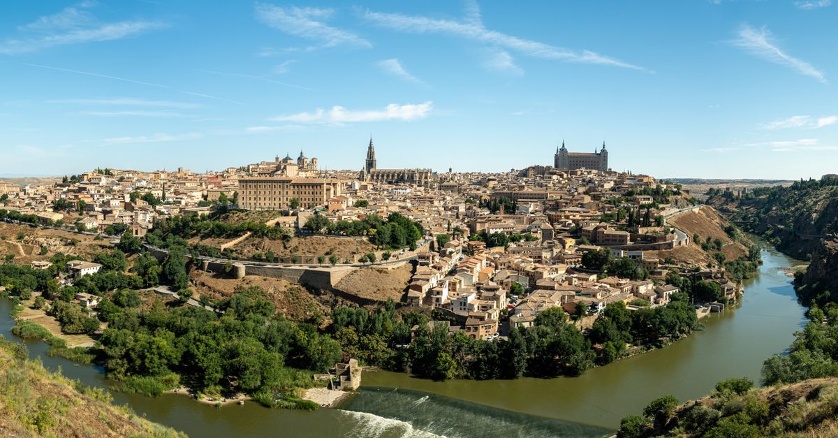 Stunning panoramic view of Toledo, Spain, showcasing historic architecture and the Tagus River under clear blue skies.