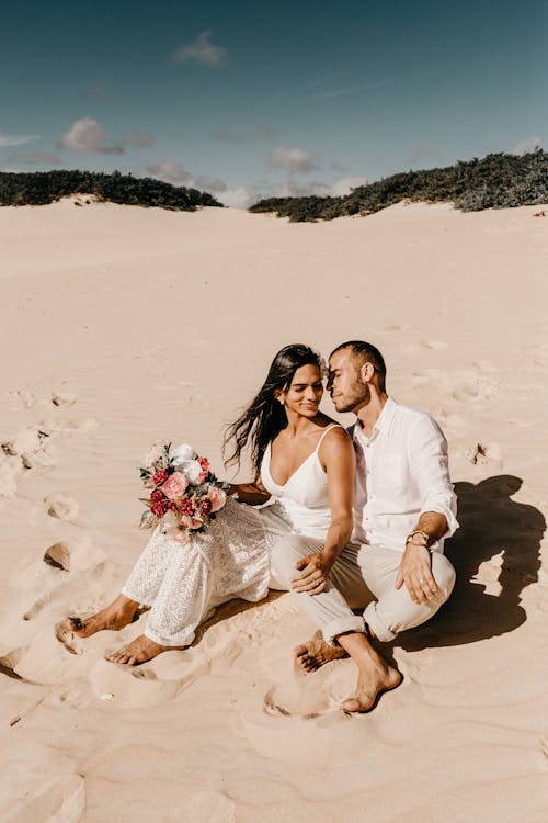 Free Photo Of Couple Sitting On Sand Stock Photo