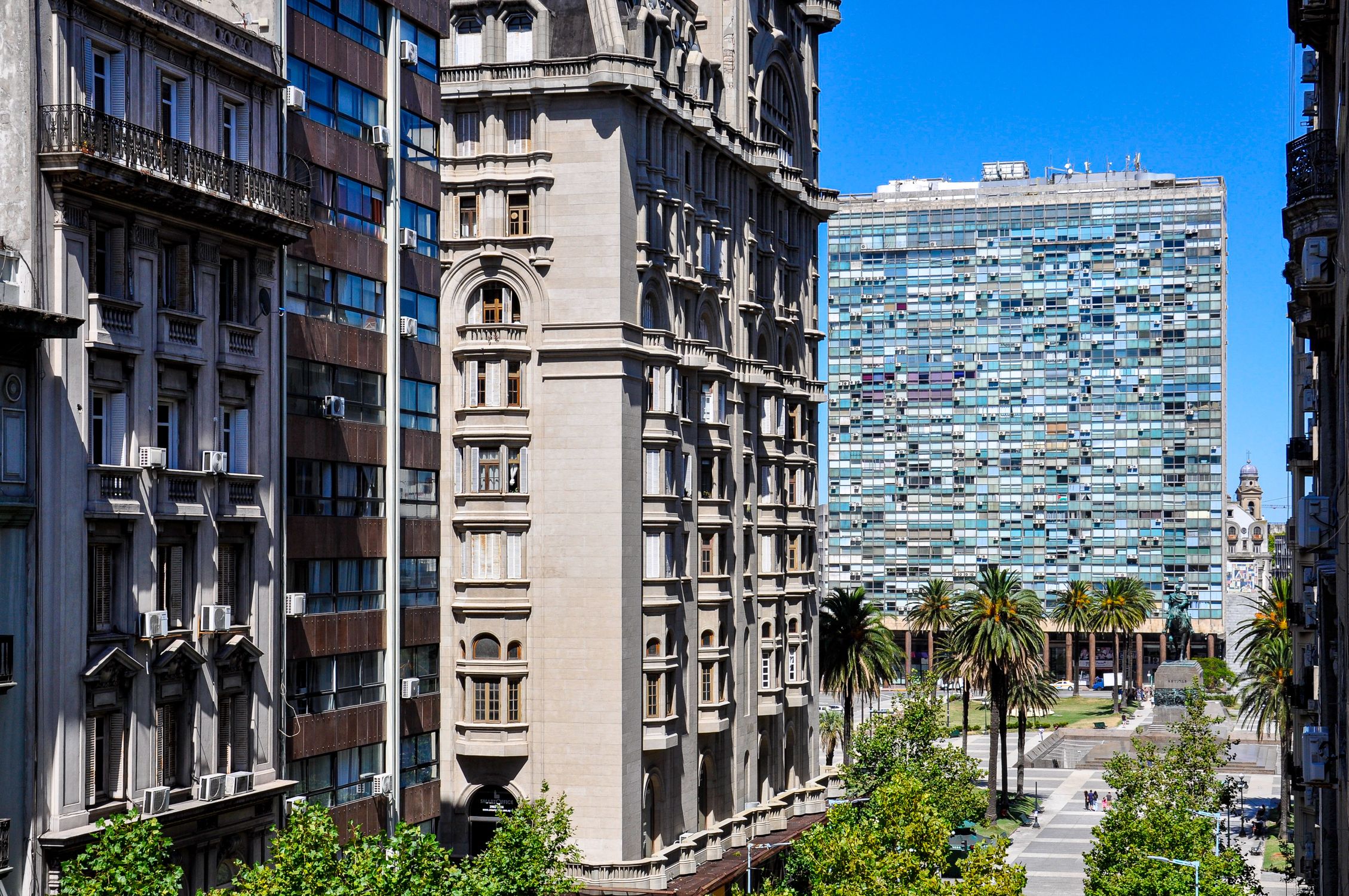 Blend of historic and modern architecture with palm trees in Montevideo, Uruguay.