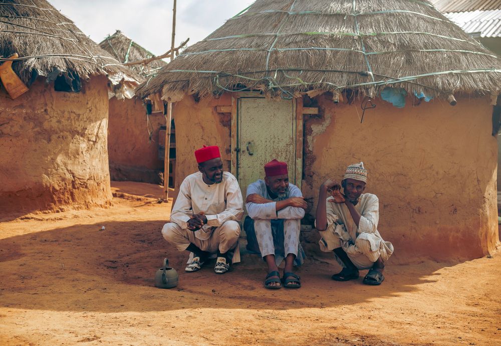 Elders gathering at a traditional Nigerian hut, sharing heritage