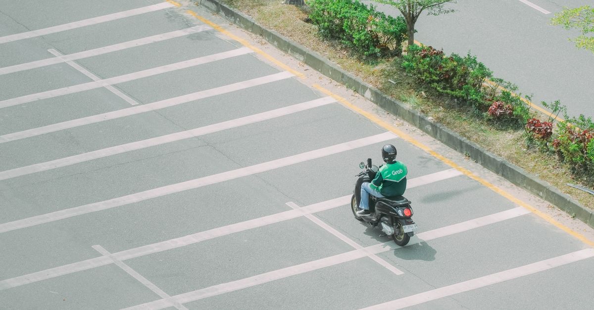 Grab Rider Background Grab Motorbike Rider on Urban Road · Free Stock Photo
